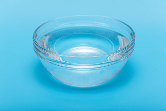Pure clear drink water in glass bowl or plate on blue background Stock Foto Adobe Stock