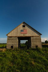 Old wooden barn with american flag. © Nicola