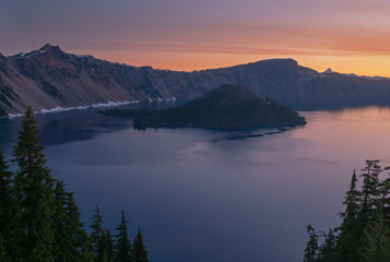 Spring landscape at dawn of Crater Lake with conifers, Wizard Island, and crater rim, Crater Lake National Park, Oregon, USA