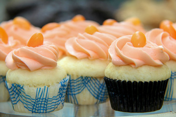 Pretty white cupcakes with pink icing topped with a candy.