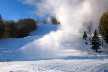 Obraz na płótnie Canvas Snow making machines billow new snow onto the ski slopes in Vermont