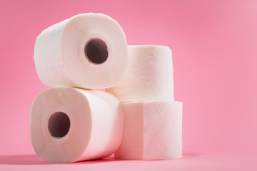 White toilet paper rolls isolated against colorful pink background.