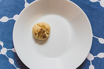 Small arabic biscuit in a white plate on a blue table.
