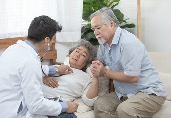 Young caucasian doctor listen heart beat by use stethoscope with senior elderly old asian female patient about disease symptom