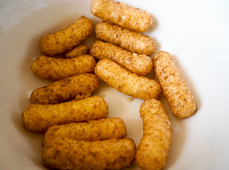 Sweet corn sticks in cocoa in a white plate . Gluten-free