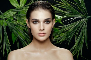 Beautiful woman naked shoulders green leaves nature cosmetics