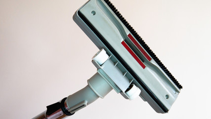  Vacuum cleaner brush facing the photo viewer. Close up of the vacuum cleaner, focus on the brush in a woman's hand on white backgrounds. 