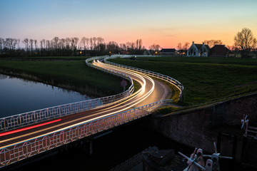 Fototapeta na wymiar Curve light trails on country road in the landscape of the province of Groningen, The Netherlands