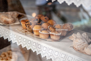 MAGDALENAS Y PANES EN ESCAPARATE DE PANADERIA DE PUEBLO RURAL