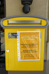 Affiche jaune mentionnant que la situation sanitaire oblige La Poste &agrave; adapter son organisation. Coronavirus. Covid-19. Saint-Gervais-les-Bains. Haute-Savoie. France.