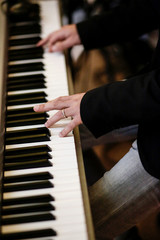 dettagli di mani che suonano un pianoforte 