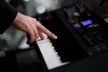 dettagli di mani che suonano un pianoforte 