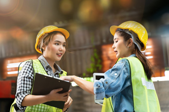 Professional Engineering Woman Worker Walk And Check In Warehouse Factory. Manager Discuss Inspection Report Paper For Internal Audit. Quality Assurance For Manufacturing Industry.