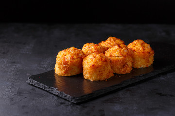 Six Tempura Fried rolls on black background