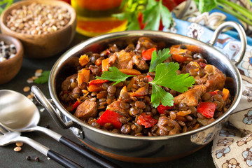 Indian food, authentic indian dish. Traditional Indian spicy green lentils with meat, spices, herbs on a stone table.