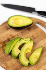 Sliced avocado on the round wooden cutting board