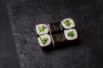 Close-up of maki sushi rolls with cucumber on black background