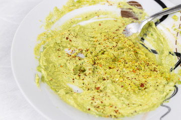 Avocado spread in the plate with with ground pepper