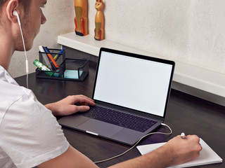 Student man wear headphones use laptop computer study online listen watch training course make...