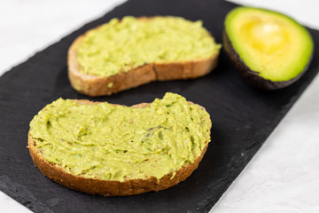 Avocado spread with grated chilly peppers on the sliced toasted bread
