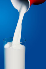 Pouring of milk from jug into a glass