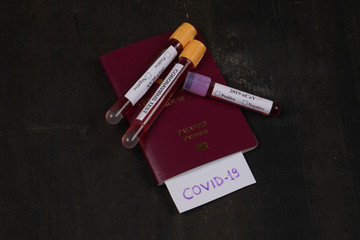 Coronavirus and travel concept on black background with blood tubes. Note the COVID-19 and...