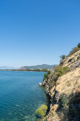Fototapeta na wymiar Huge rock on the right and beautiful lake Ohrid on the left. North Macedonia, August, 2019