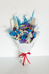 Bouquet of dried flowers in blue and purple.  Dried flowers of cotton, wheat, lavender, statice (kermek), munni and others. Flower composition.