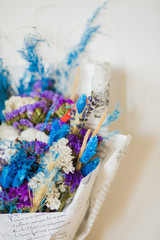 Bouquet of dried flowers in blue and purple.  Dried flowers of cotton, wheat, lavender, statice (kermek), munni and others. Flower composition.