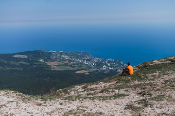 Traveler sitting on cliff mountains. Life on the edge. 