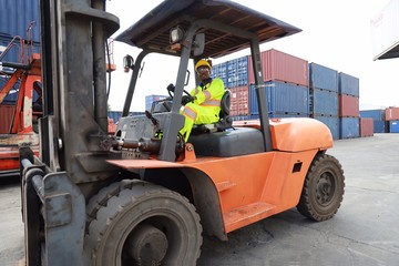a worker drives a forklift at the container yard