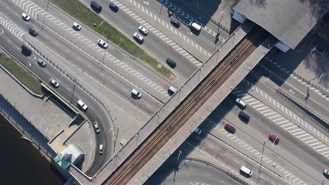 Drone aerial footage of a subway station without people and trains due to coronavirus quarantine. But average cars and trucks traffic driving highway underneath the station.