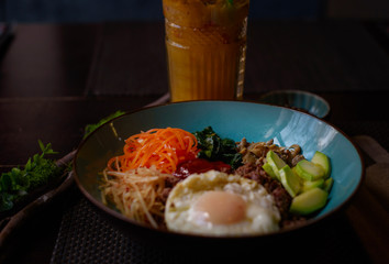 Korean dish bibimbap  - mixed rice with meat and assorted vegetables on dark background
