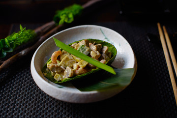 salad of prawns, mushrooms and avocado in half avocado on a dark background