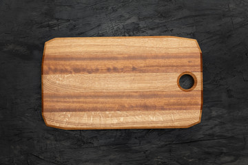 Wooden board, for cutting food in the kitchen, on black background