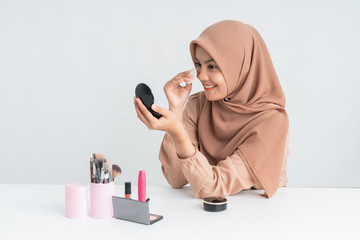 beautiful young muslim woman applying make up