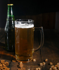 On a wooden table is a mug of cold foamy beer. Close-up. Black background.