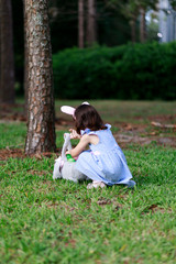 Little toddler girl with bunny ears. Easter egg hunt. - 337056437