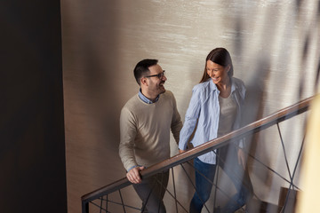 Couple holding hands and walking up the stairs