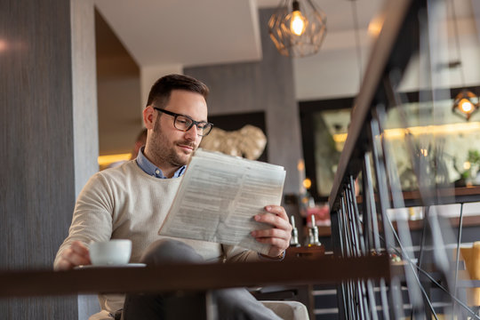Man reading newspaper in restaurant