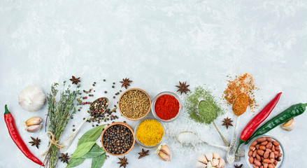 A variety of spices and herbs on a light table. Cooking background. View from above. Ingredients for cooking. Table background menu. Copy space.