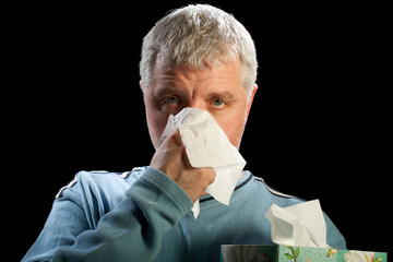man blowing his nose with tissue box