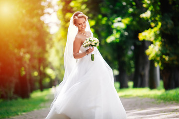 Fototapeta na wymiar beautiful blonde bride enjoys her wedding day in the summer