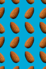Seamless pattern of almonds on a blue background. top view.