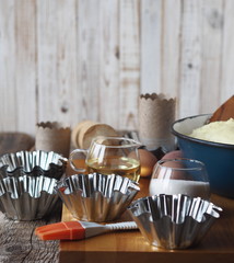 Dough for Easter cakes, croissants, or bread on the background of molds for Easter cakes and ingredients for kneading dough.