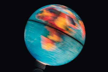 Illuminated world globe spinning with black background