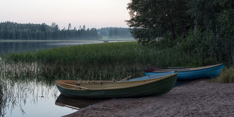 Naklejka na ściany i meble boat on the shore of a forest lake