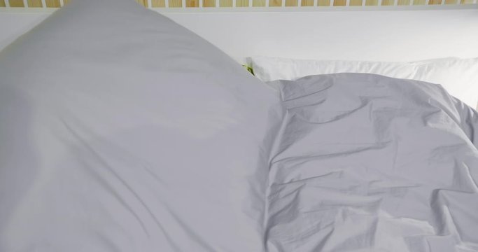 Elderly couple caressing in bed under blanket