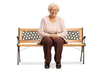Senior woman sitting on a bench and smiling at the camera
