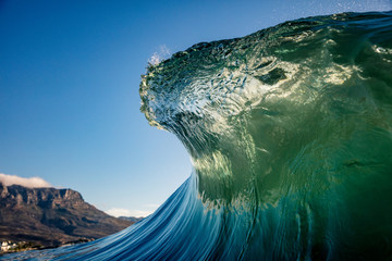 emerald wave curling with mountains in the background